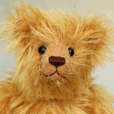 Close up of Podgerson teddy bear's face, a bear made from the Podgerson teddy bear kit sitting on a wooden surface 