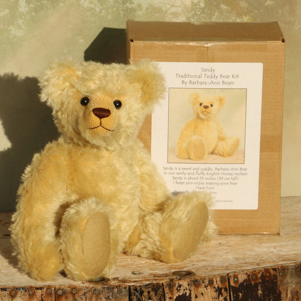 Sandy Teddy Bear Kit by Make A Teddy, showing our Sandy teddy bear in beautiful gold mohair sitting by the box containing the teddy bear kit