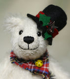 Theo's face and hat.
Theo sitting and waving. The Christmas Teddy bear sewing kit makes Theo who is a 6.5”/ 17cm (approx) fully jointed, white mohair (12mm sparse) bear wearing a black felt hat with felt holly leaves, red glass berry beads and a star sequin plus a tartan scarf with a yellow glass bead. He has black glass eyes , a cute little tail and a black embroidered nose. He is quite heavy and squidgy and very smiley.