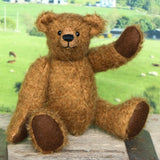 Treacle teddy bear kit by Make A Teddy, Treacle teddy bear on a wooden surface with a scenic background