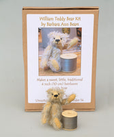 William sitting next to a reel of thread and in front of his kit box. William Miniature Mohair Teddy Bear Kit. A jointed teddy bear kit by Make A Teddy to make a 4 inch/10 cm teddy bear.