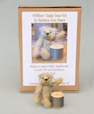 William sitting next to a reel of thread and in front of his kit box. William Miniature Mohair Teddy Bear Kit. A jointed teddy bear kit by Make A Teddy to make a 4 inch/10 cm teddy bear.